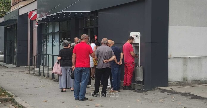 skupina penzionera stoji u redu da podigne penzije