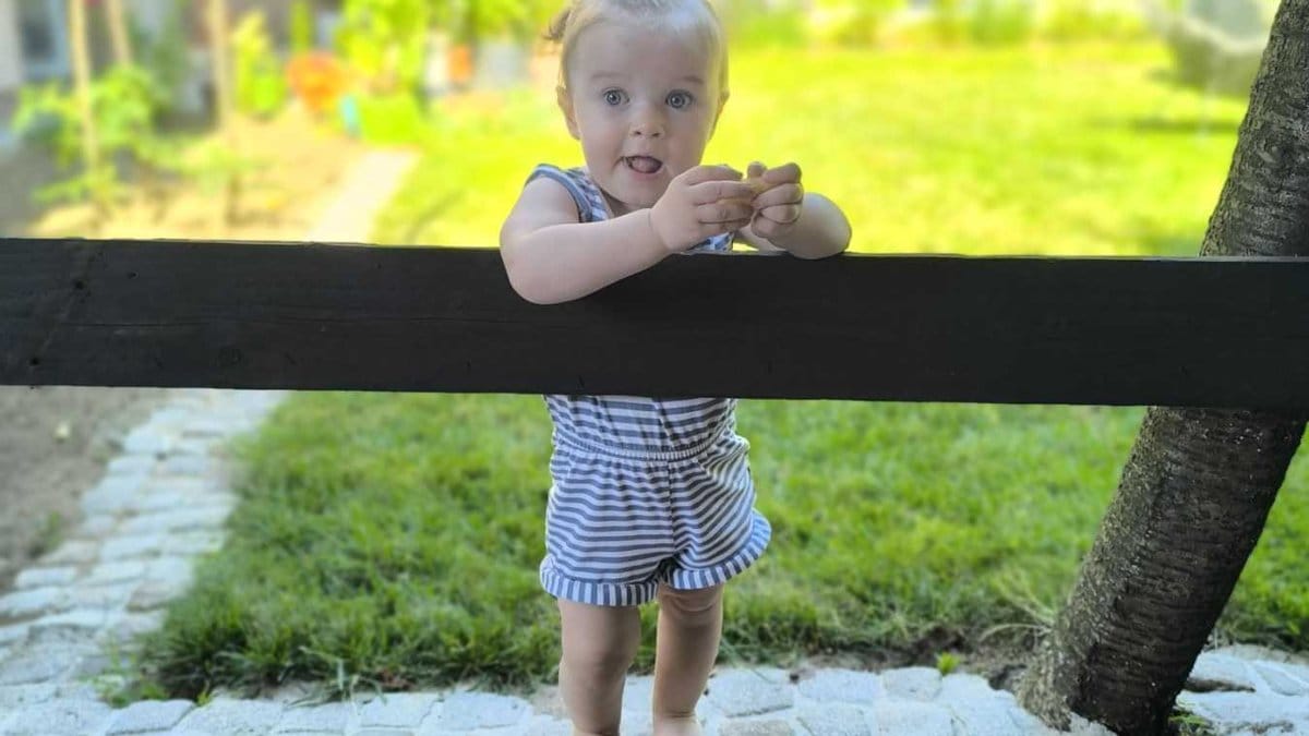 Izleti u prirodi sa malom djecom – beba stoji bosa na travi i istražuje svijet oko sebe