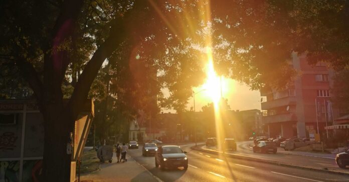 početak ljeta 2025. ljeto, tuzla. Zalazak sunca kroz gradsko drveće u Tuzli tokom ljeta