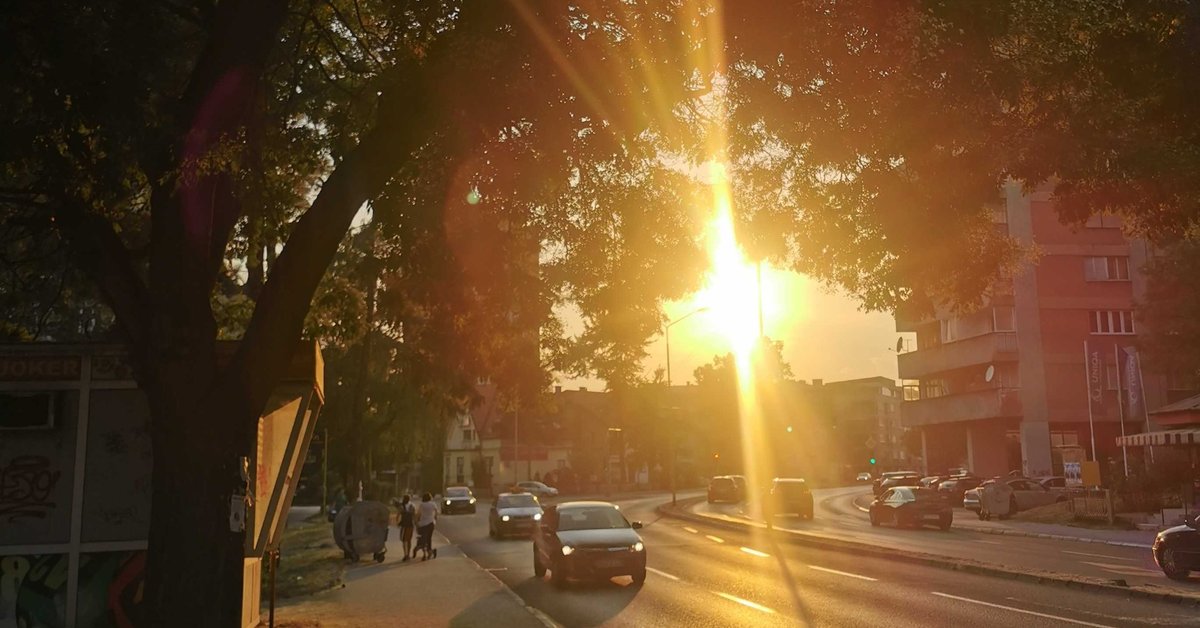 početak ljeta 2025 naslovna tuzla ljeto početak ljeta 2025. ljeto, tuzla. Zalazak sunca kroz gradsko drveće u Tuzli tokom ljeta