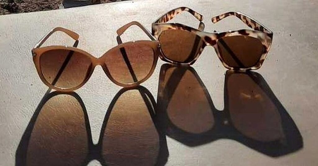 kreme za sunčanje, Sunčane naočale na stolu pod sunčevom svjetlošću, simbolizuju zaštitu očiju od UV zraka