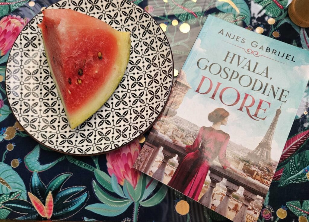 Pet knjiga za čitanje, : Knjiga Hvala gospodine Diore uz tanjir lubenice na ljetnom stolu