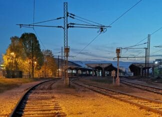 Ljubav u Sarajevu, Željeznička stanica u Sarajevu u sutonu, sa prugama koje se račvaju i toplim svjetlima koja nagovještavaju dolazak i odlazak vozova.