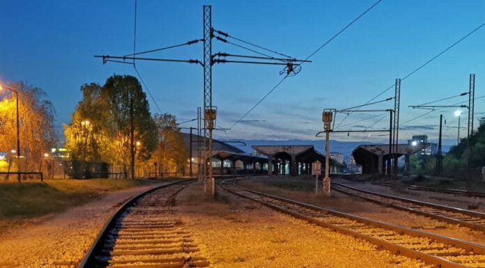 Ljubav u Sarajevu, Željeznička stanica u Sarajevu u sutonu, sa prugama koje se račvaju i toplim svjetlima koja nagovještavaju dolazak i odlazak vozova.