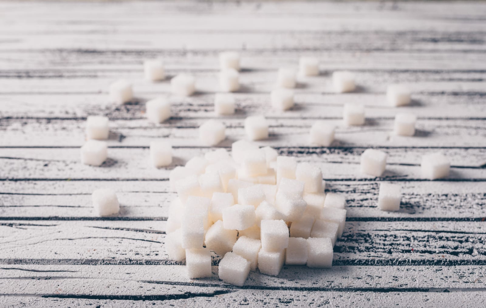 White sugar cubes on a white wooden background. high angle view.