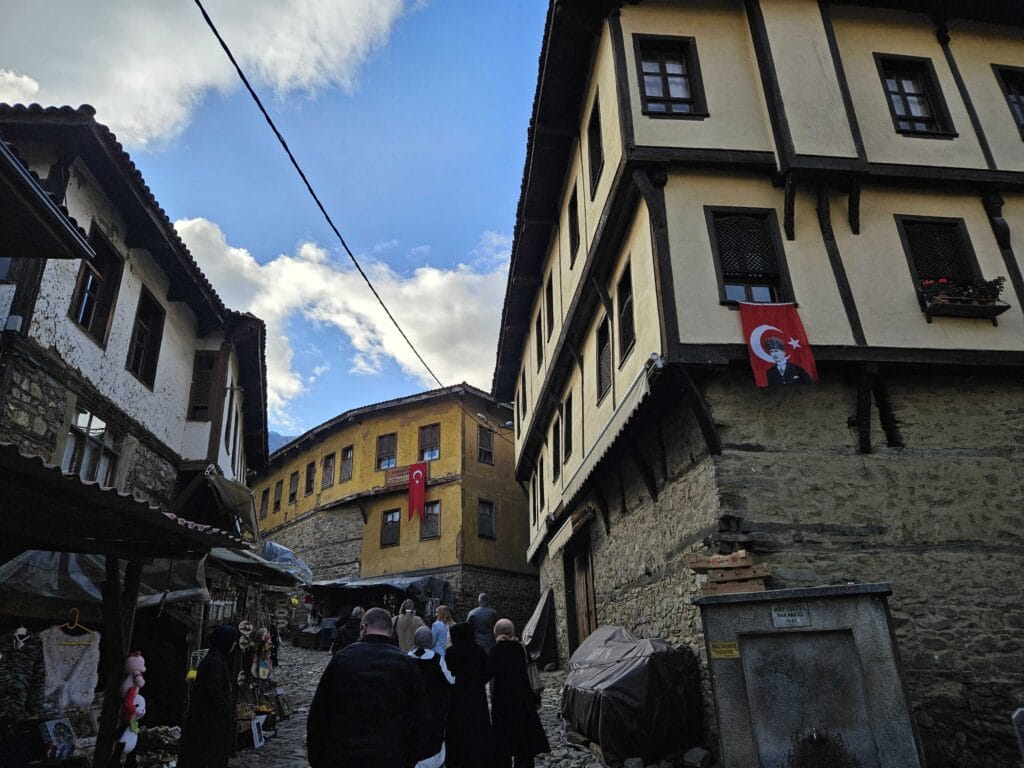 Uska kaldrmisana ulica u selu Cumalikizik s tradicionalnim kućama i prolaznicima