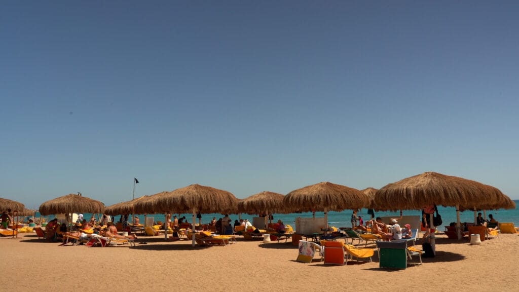 Hurgada iz Tuzle pješčana plaža sa suncobranima i turistima