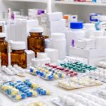 liječenje malignih oboljenja; Velika količina lijekova i medicinskih preparata na stolu u apoteci
