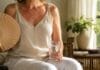 Ljetne vrućine u menopauzi: Kako lakše izdržati dan i noć Ljetne vrućine u menopauzi, Žena se rashlađuje lepezom i vodom tokom ljetnih vrućina u menopauzi