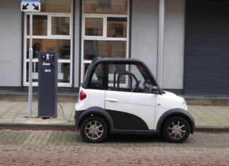 Isplati li se danas preći sa benzinca na električni automobil? Mali beli električni automobil priključen na stanicu za punjenje