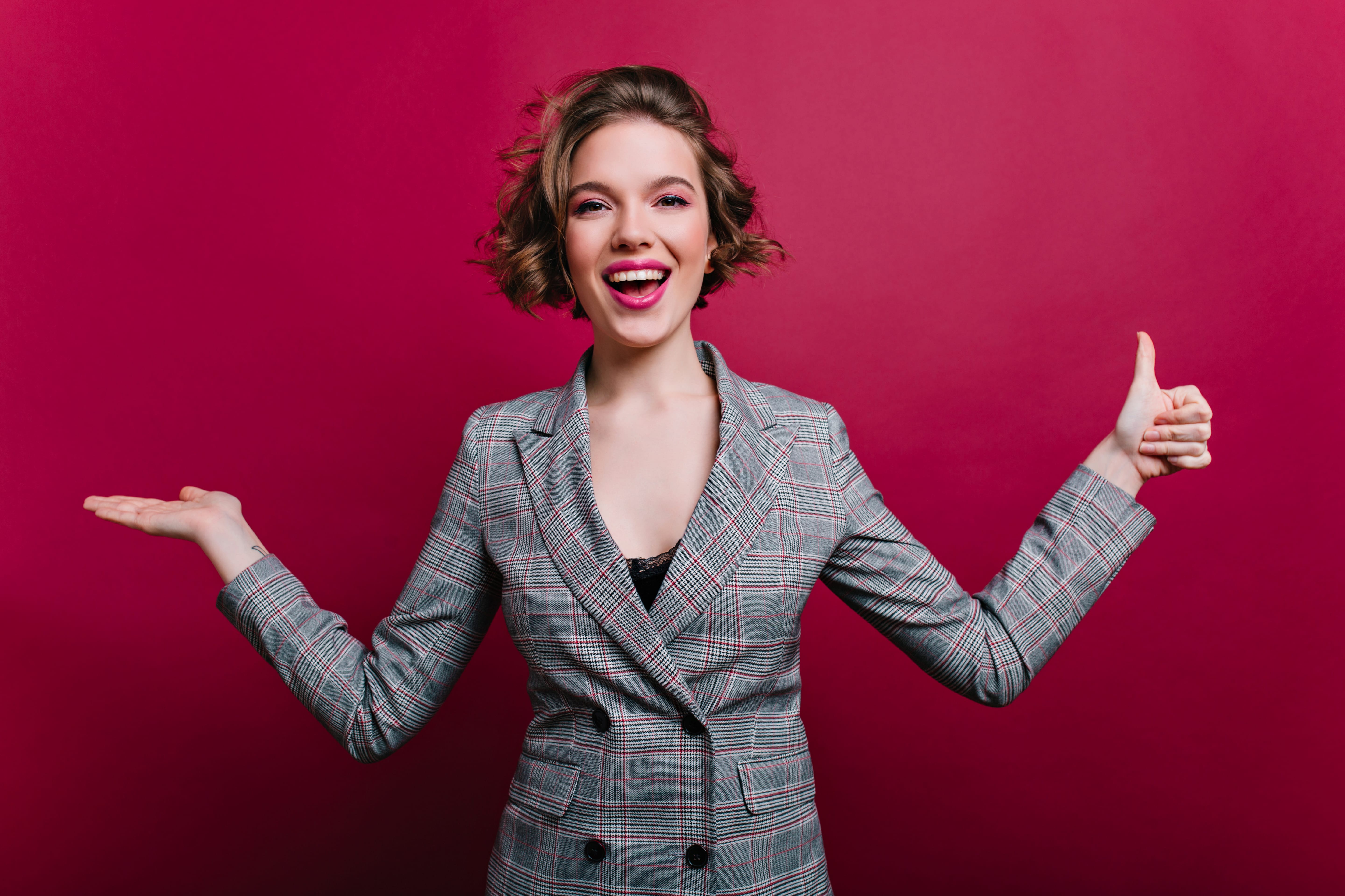 Refined pale girl with curly hairstyle posng on claret background after workday. Indoor portrait of graceful business-woman in gray jacket smiling in studio.. Žene čine 42 posto kandidata, ali predvode tek svaku šestu izbornu listu
